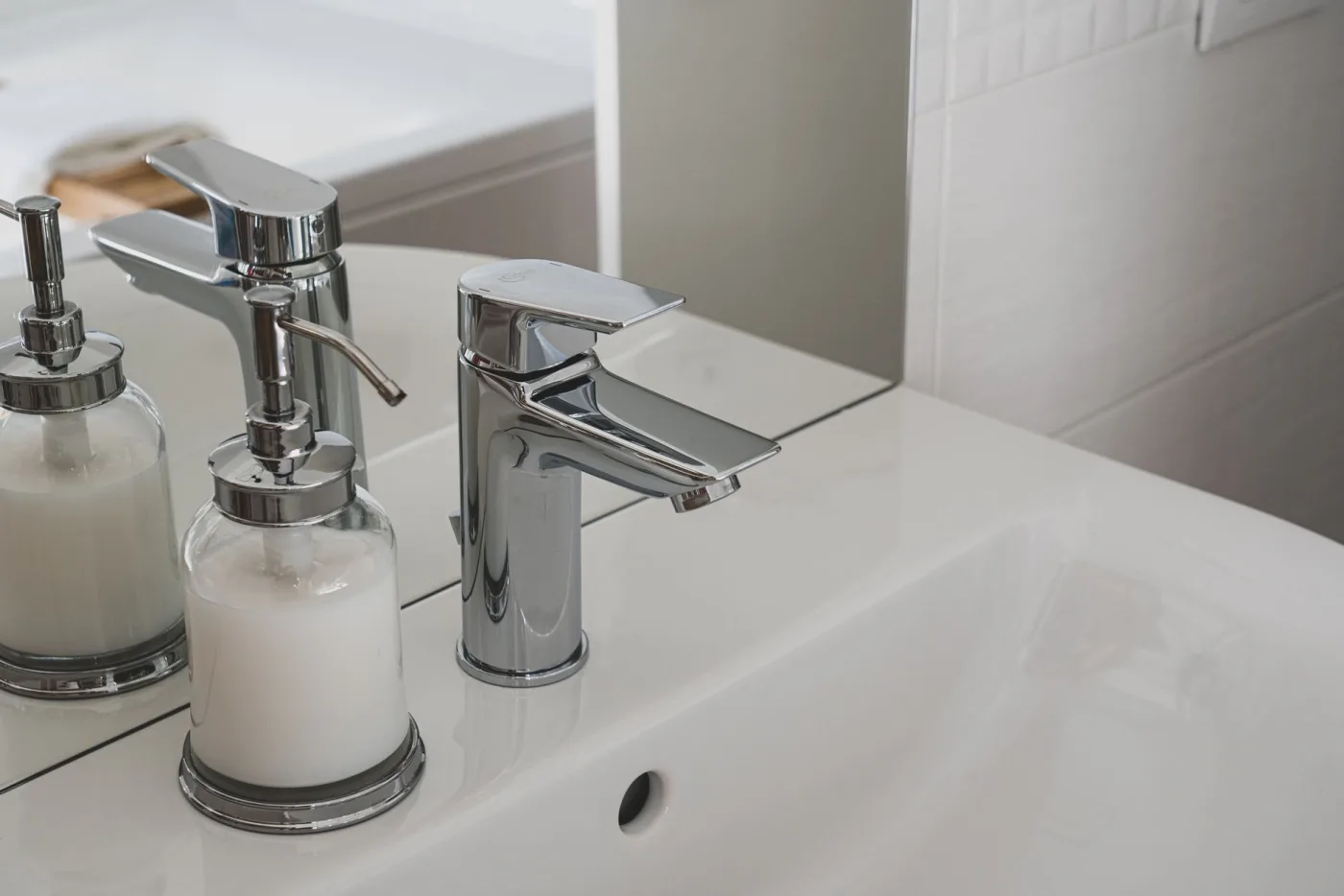 Chrome bathroom faucet and fittings installed on a bright vanity
