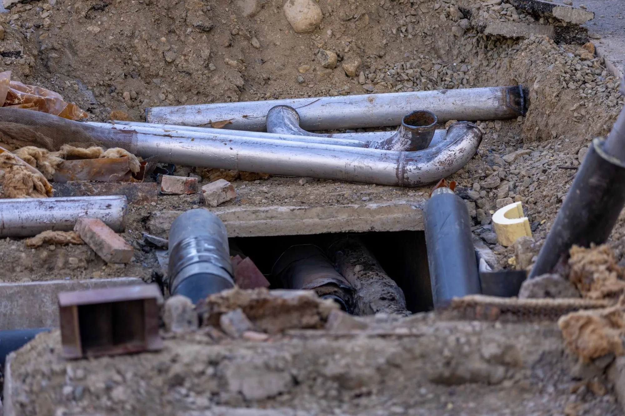 Sewer and water lines exposed in an open trench during an Atlanta plumbing repair