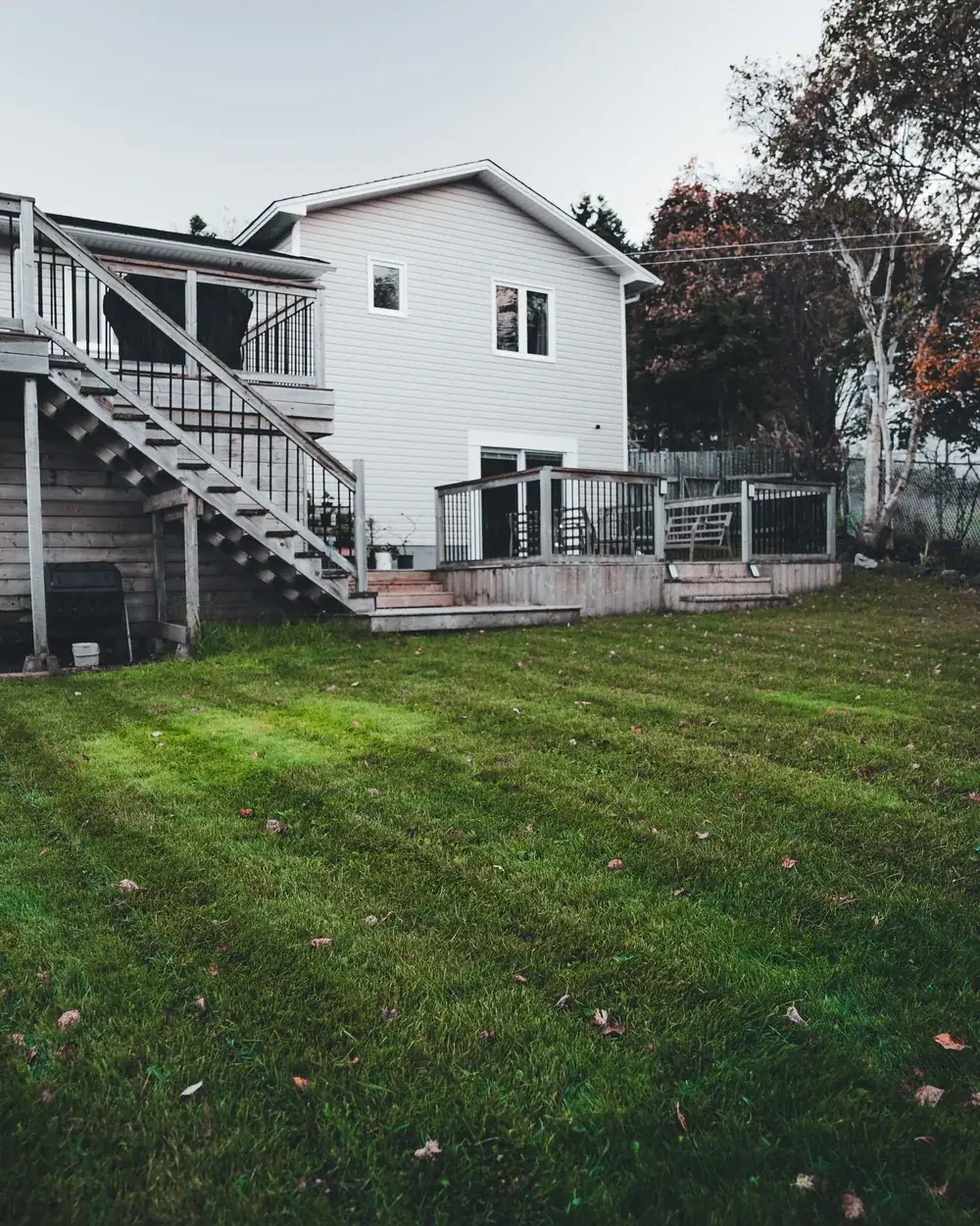 A freshly mown Charlotte front lawn with sharp bed edges, fresh pine straw and trimmed shrubs along a brick house