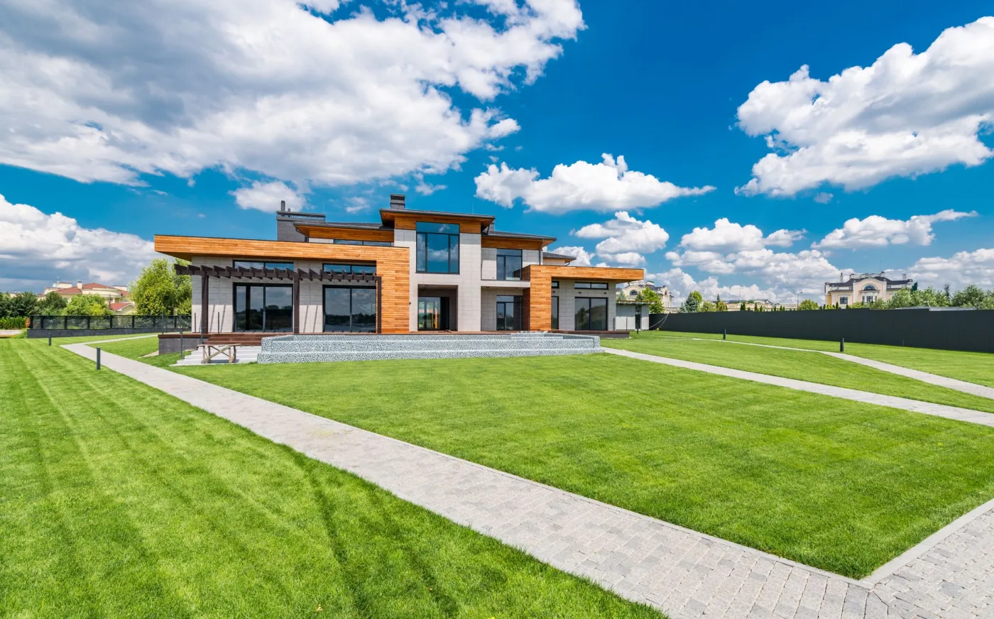A striped, manicured lawn running alongside a modern home
