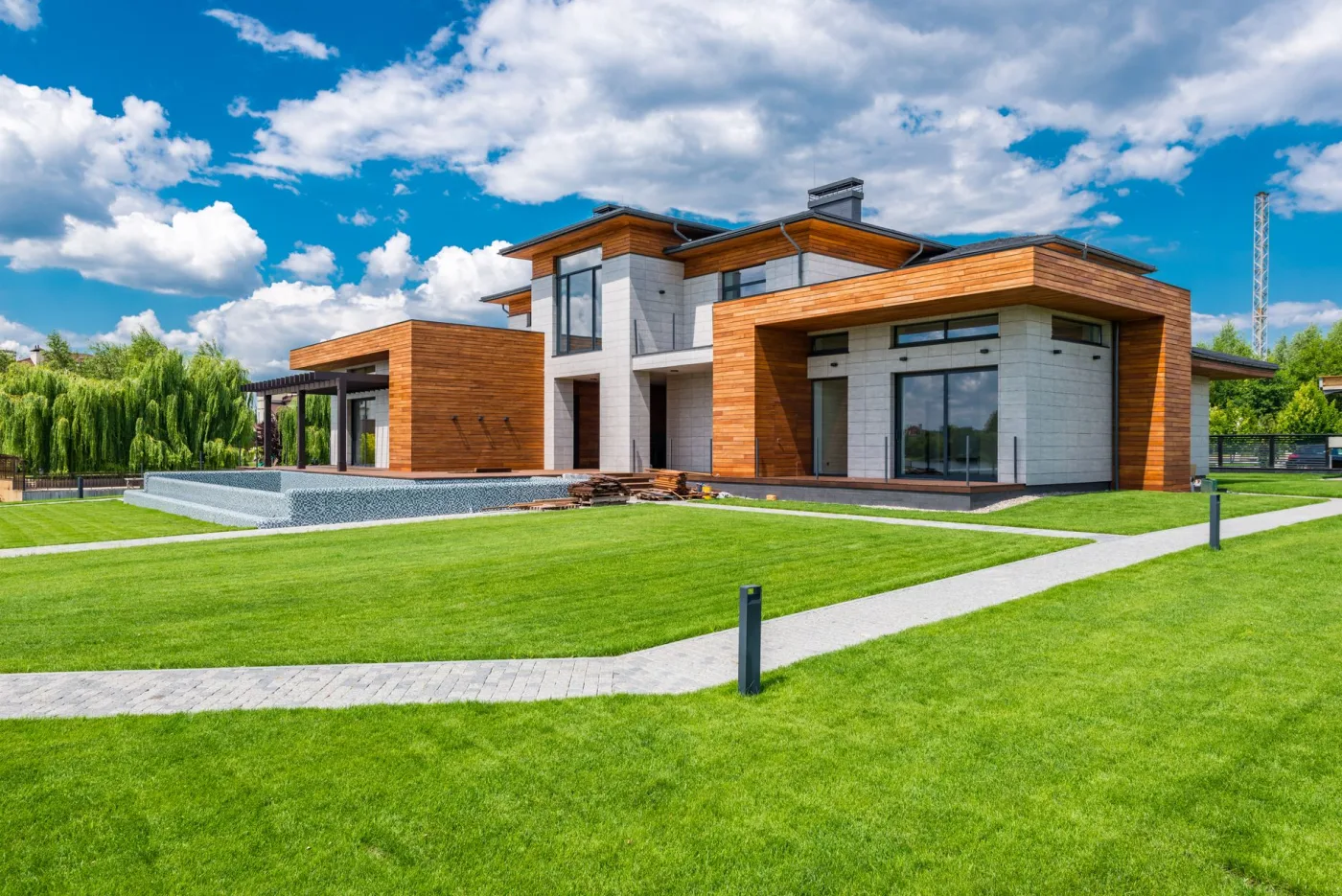 A modern home with a wide green lawn and clean landscaping