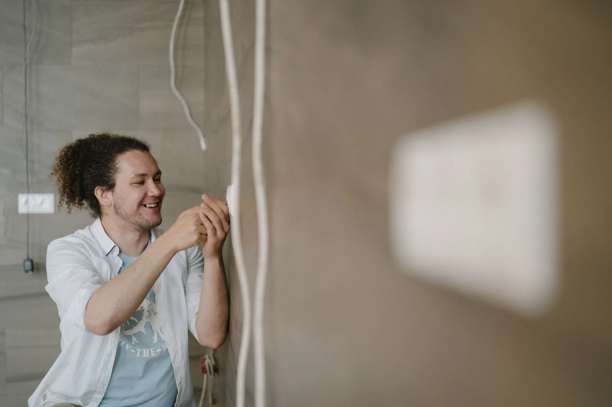 BROUNCO electrician wiring a wall outlet inside an Atlanta home