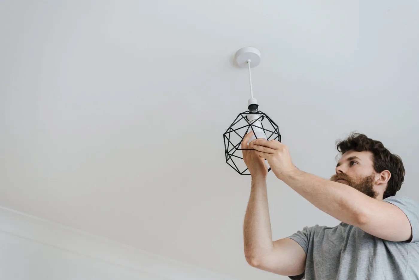 CBX electrician installing a ceiling light fixture