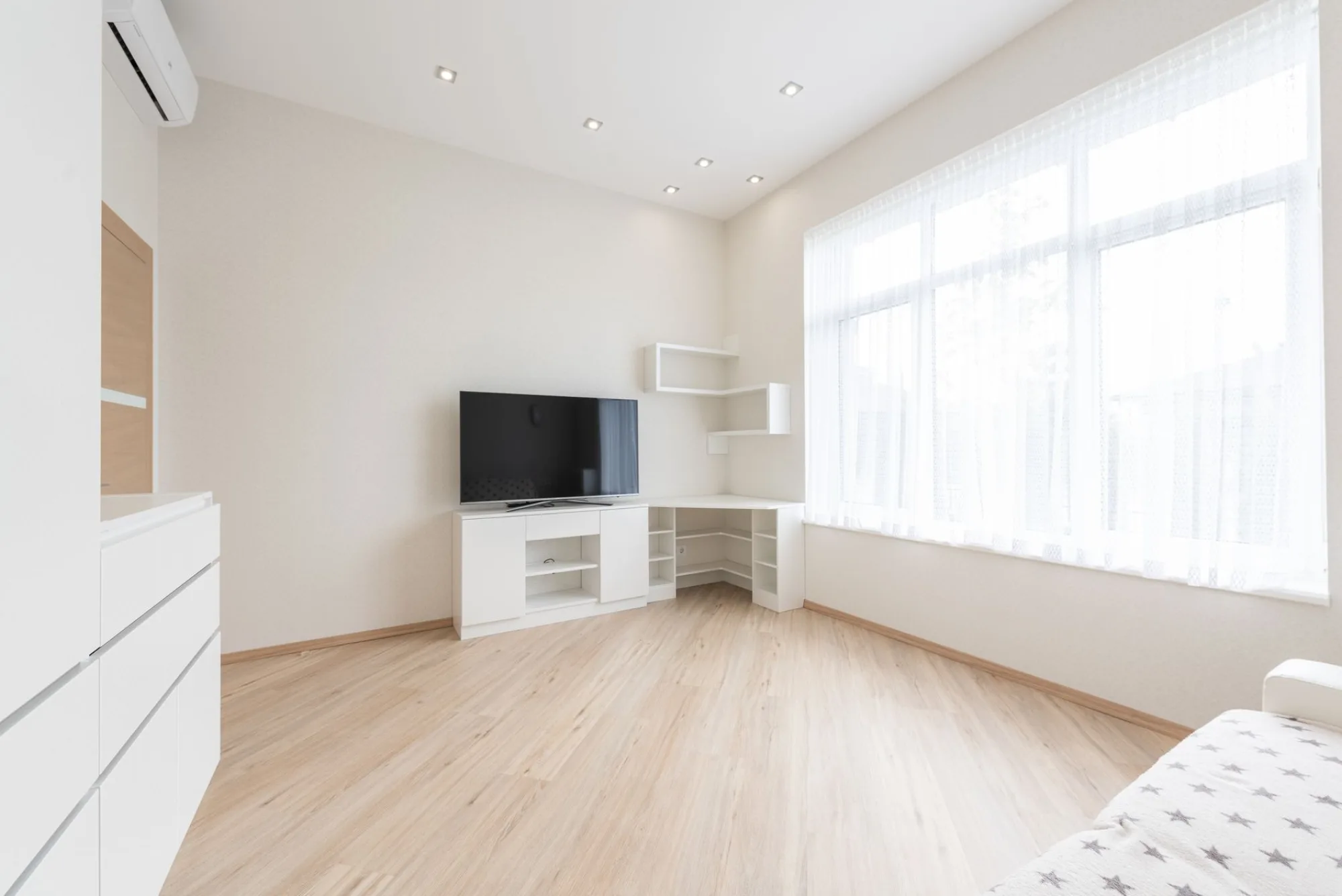 A freshly finished Atlanta room with clean hardwood floors and clear windows after a post-construction cleaning