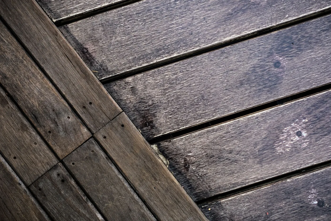 A wood deck mid clean, showing the grey dirty boards on one side and the fresh clean wood on the other
