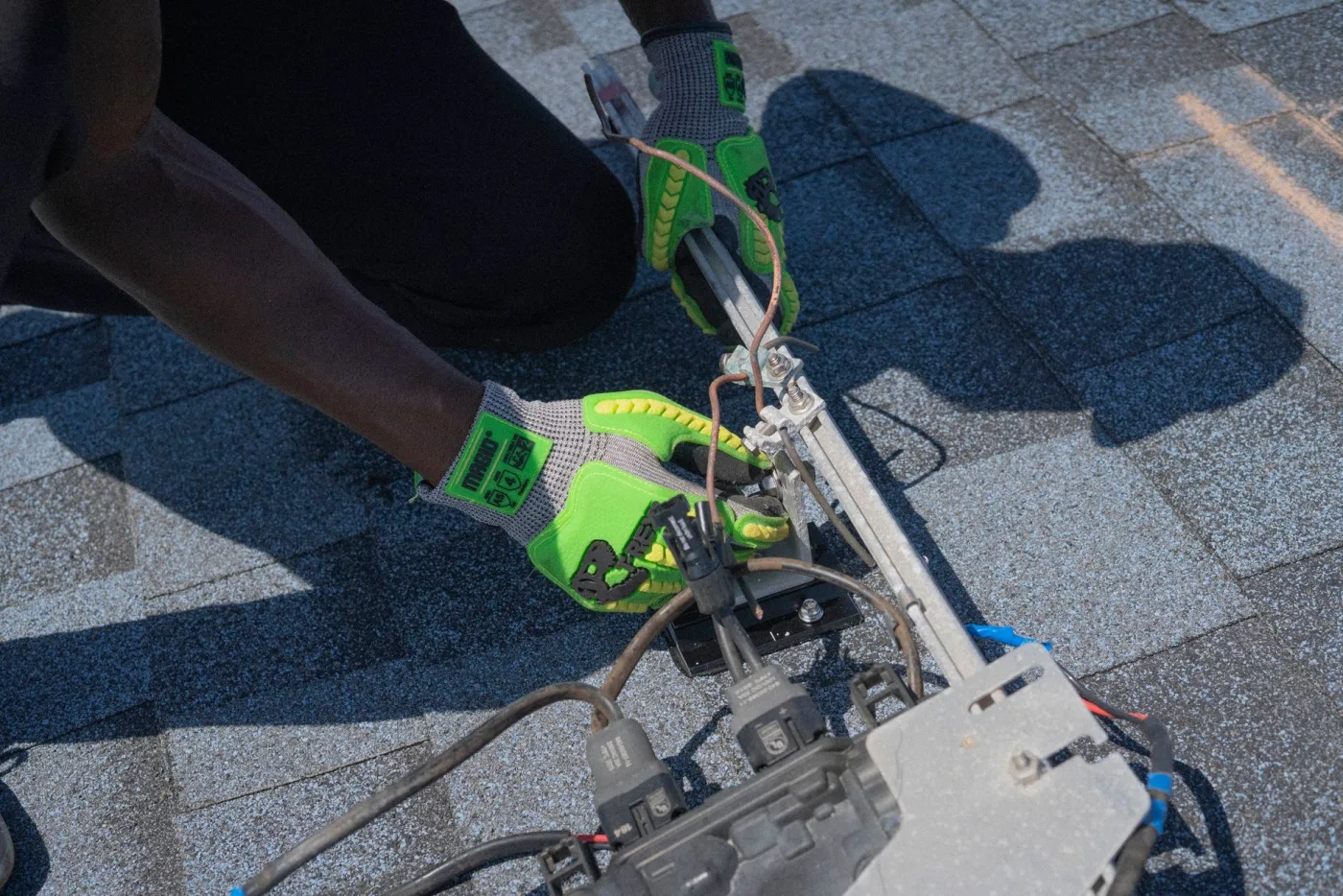 Electrician doing rooftop electrical work while wearing safety gloves