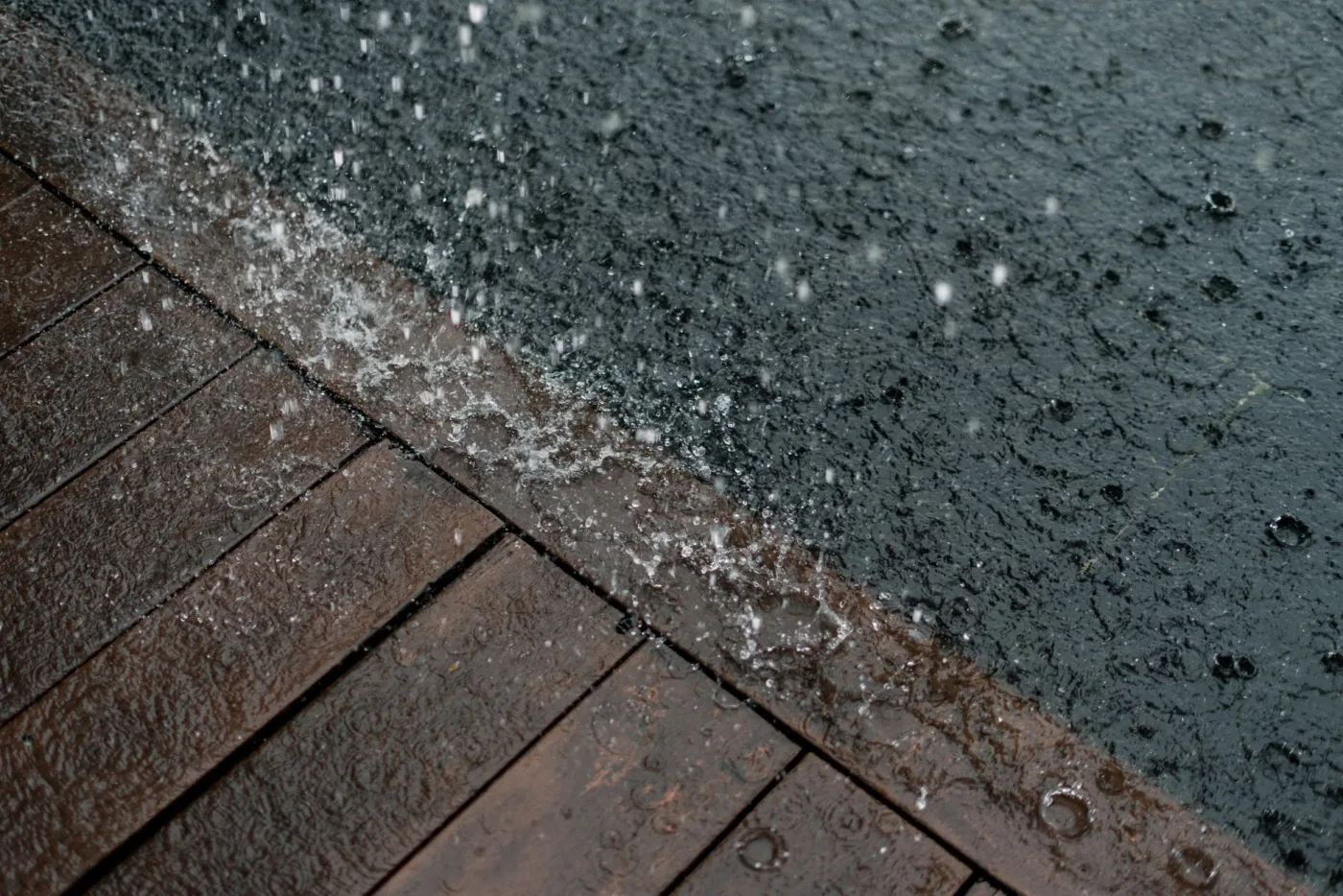 A deck mid wash, dark grime on one side and clean wood emerging on the other
