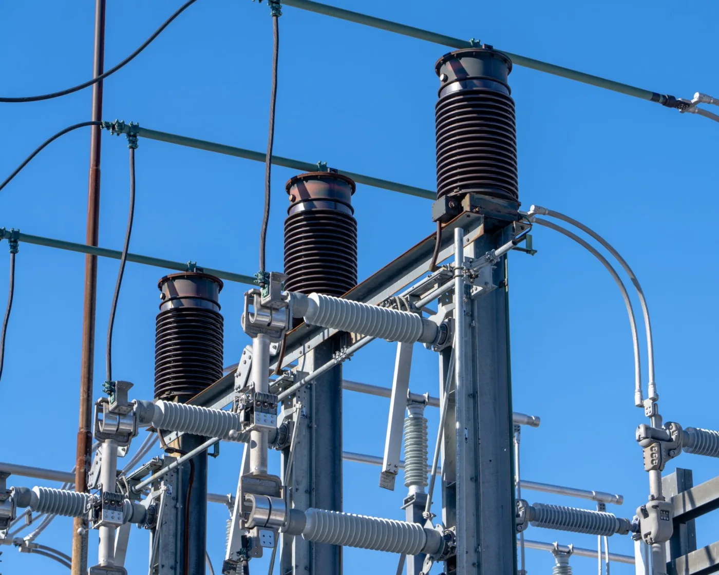 High-voltage power lines against a clear blue sky