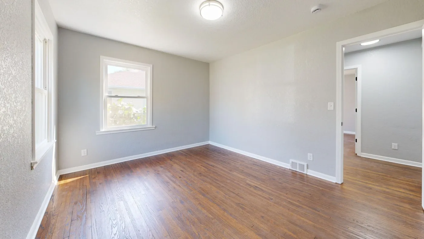 Refinished bedroom with restored hardwood floors and fresh paint