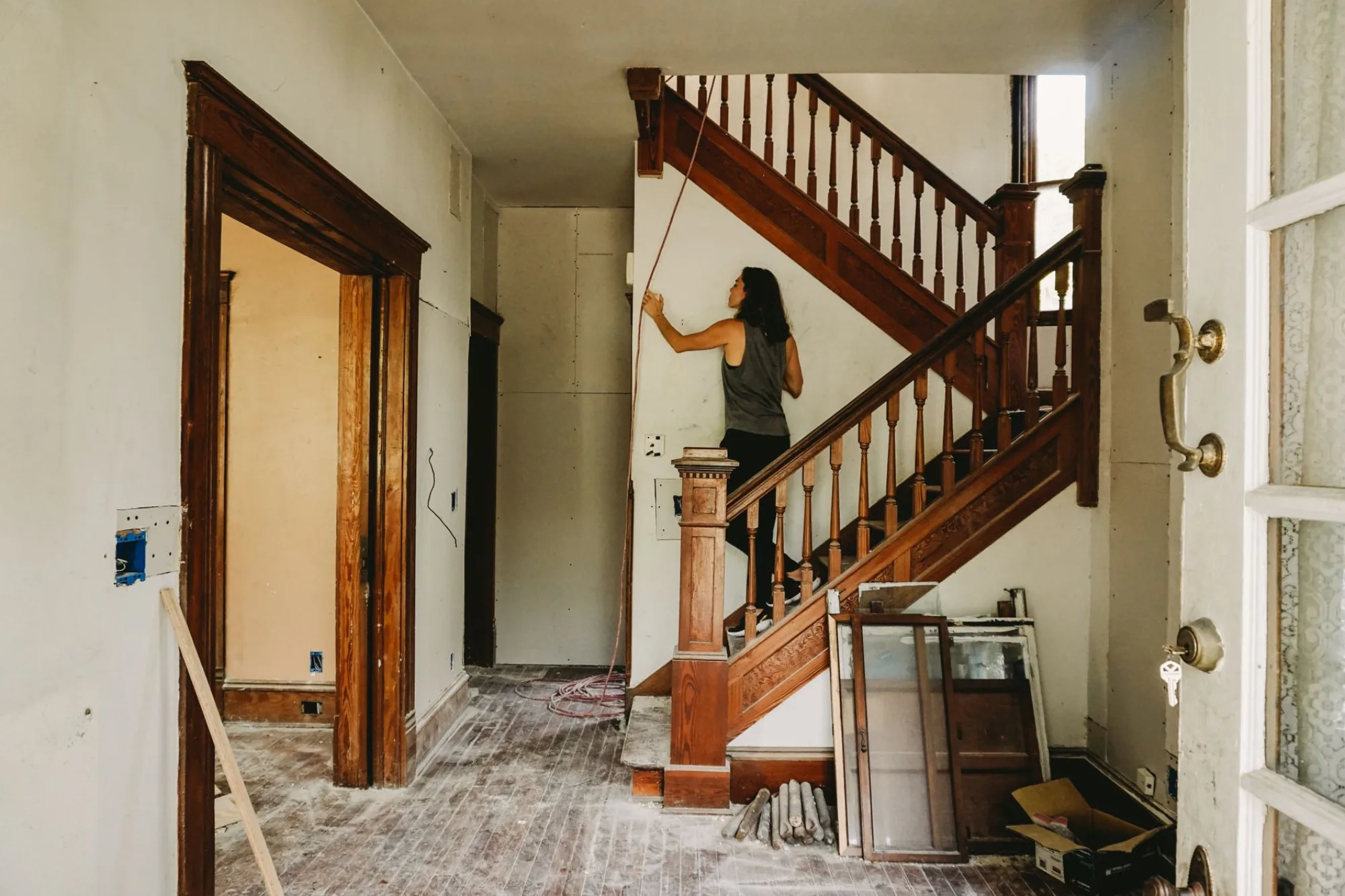 Interior of an Atlanta home mid-renovation, with a restored wood staircase and bare subfloor
