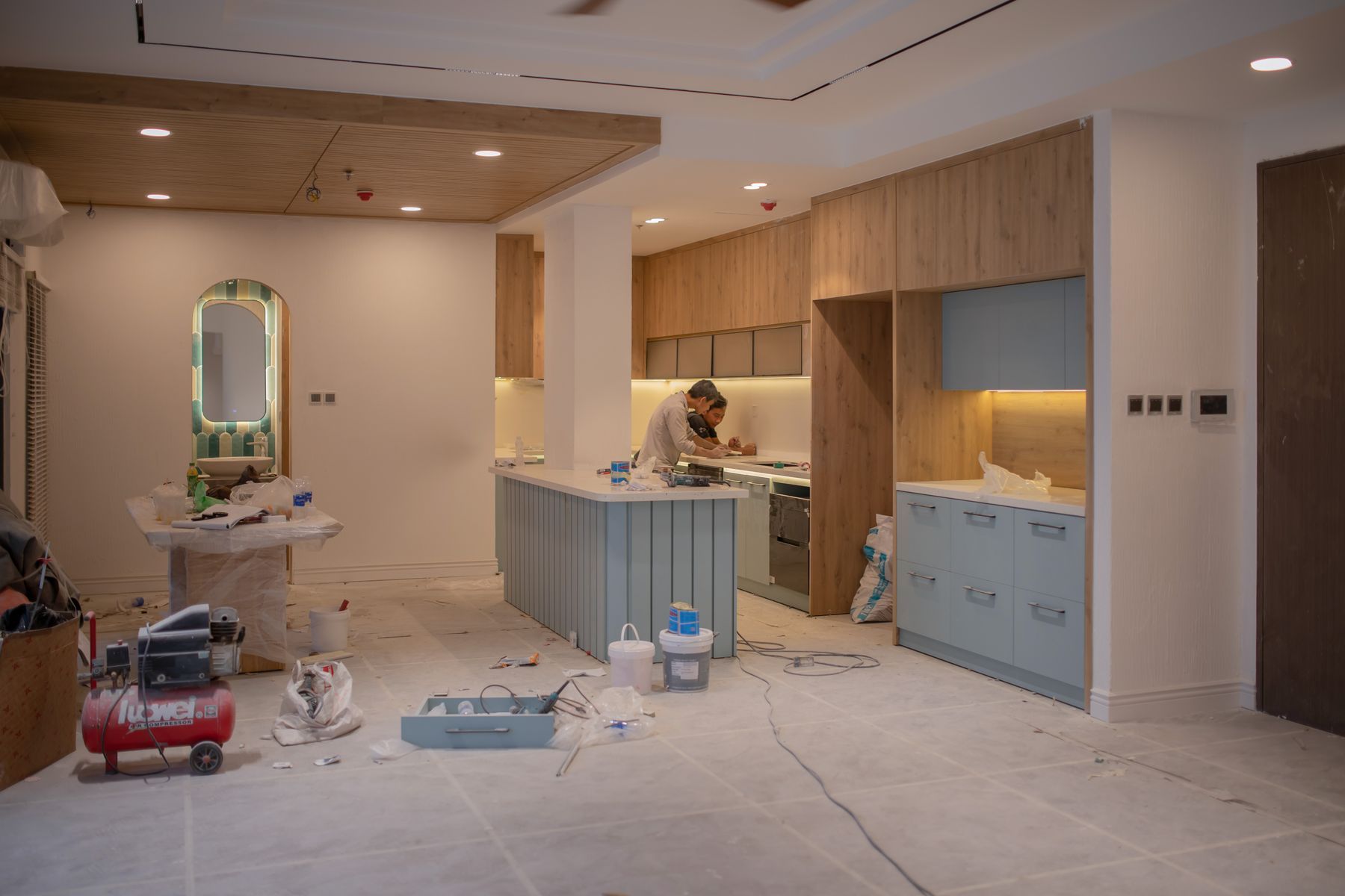 A kitchen mid renovation with cabinets set, floors protected and tools still on site.