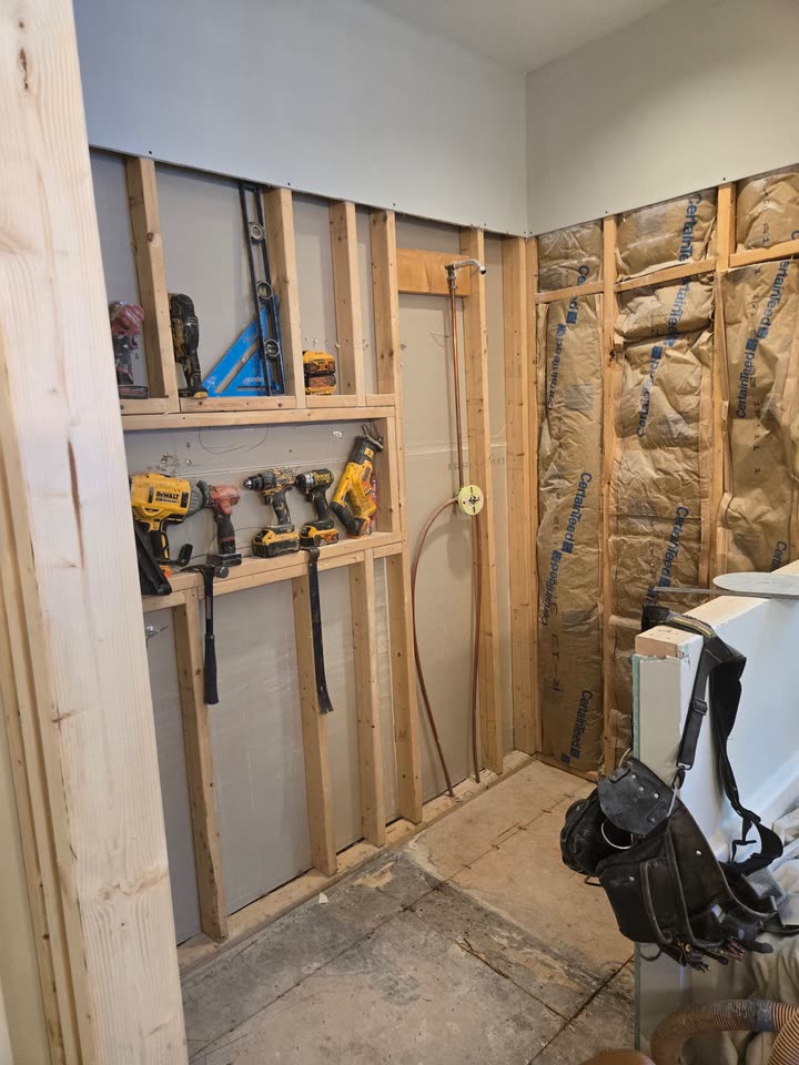 The framed wall from the doorway, drywall stacked and ready to go back on.